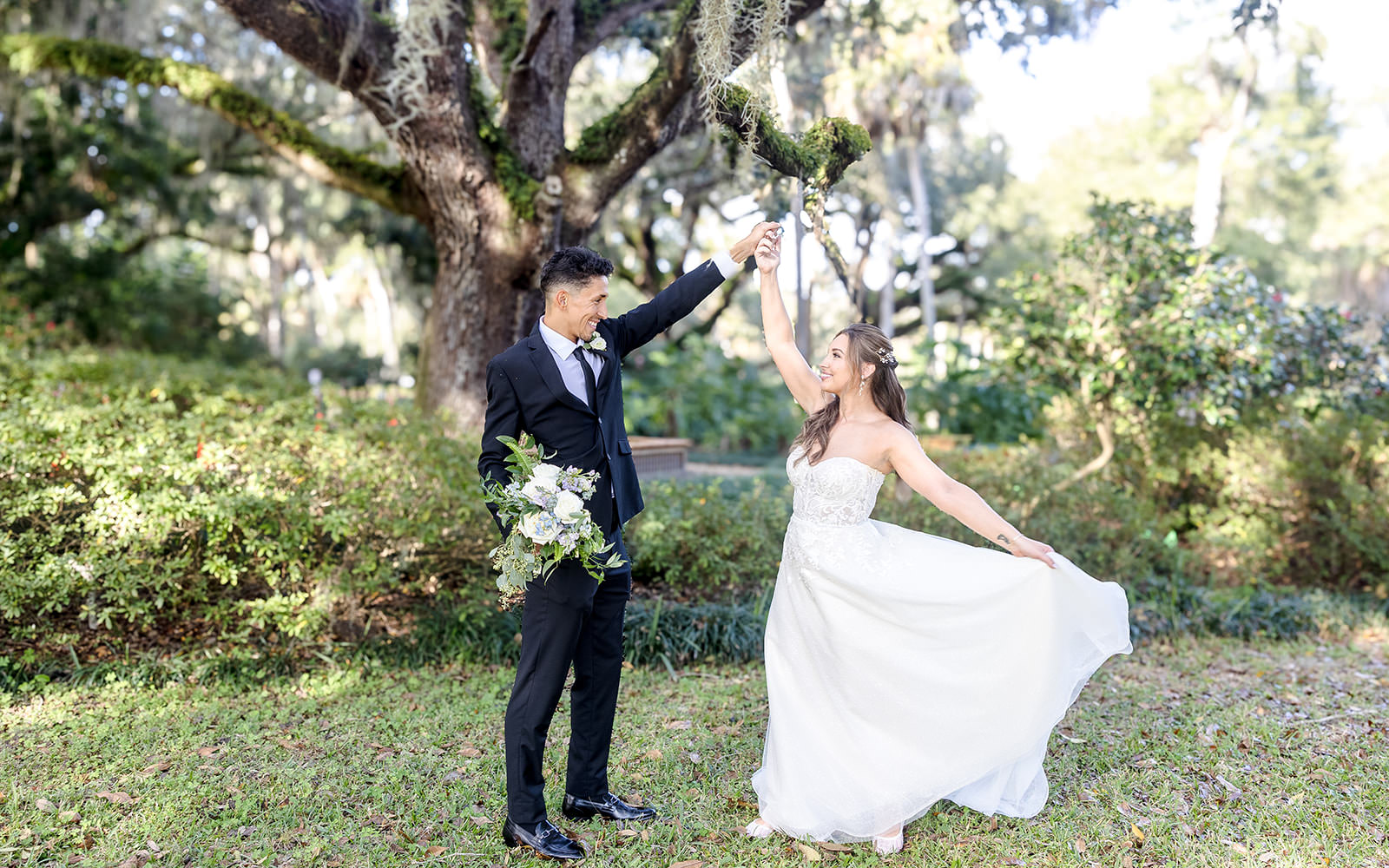 St Augustine based wedding under a large mossy oak tree. groom twirling bride